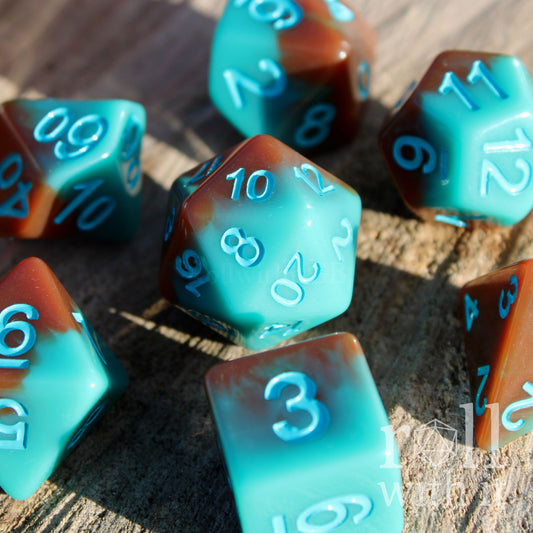 Set of turquoise blue and chocolate brown polyhedral roleplaying dice on a wooden surface