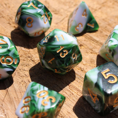 Set of green and white swirling polyhedral DND dice with gold numbers on a wooden surface