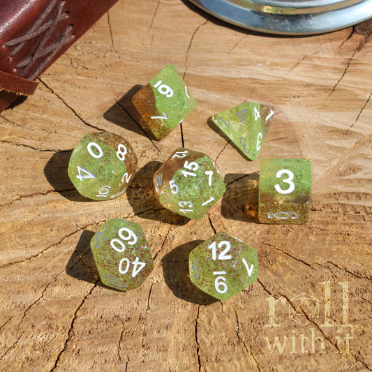 Overhead set of green polyhedral dice on a wooden surface