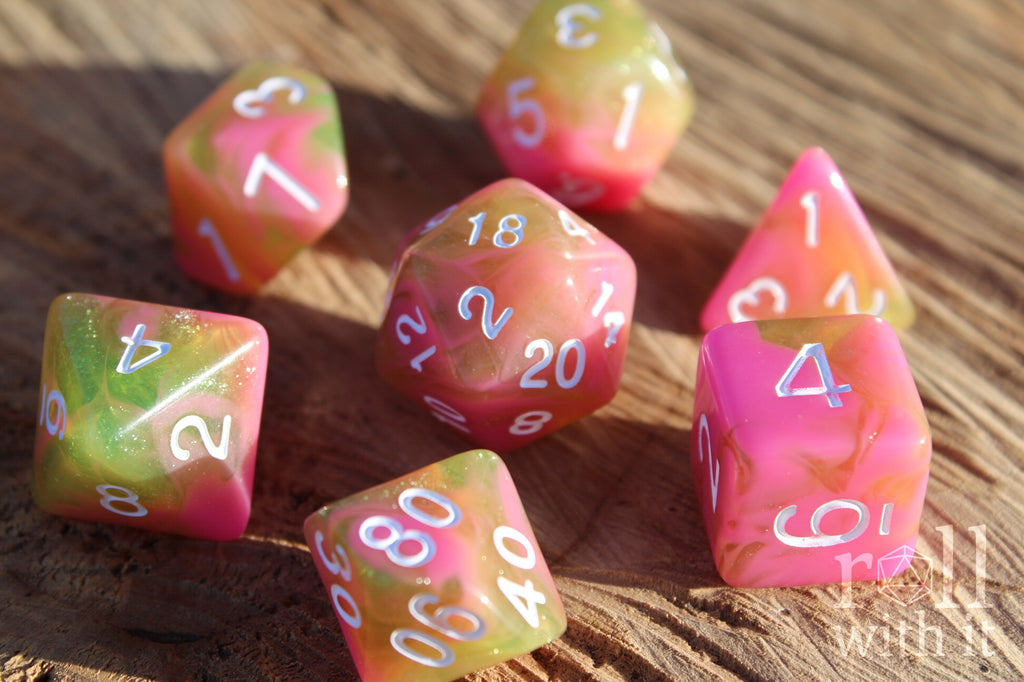 Set of candy pink and green with glitter polyhedral role playing dice on a wooden surface