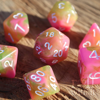 Set of candy pink and green with glitter polyhedral role playing dice on a wooden surface