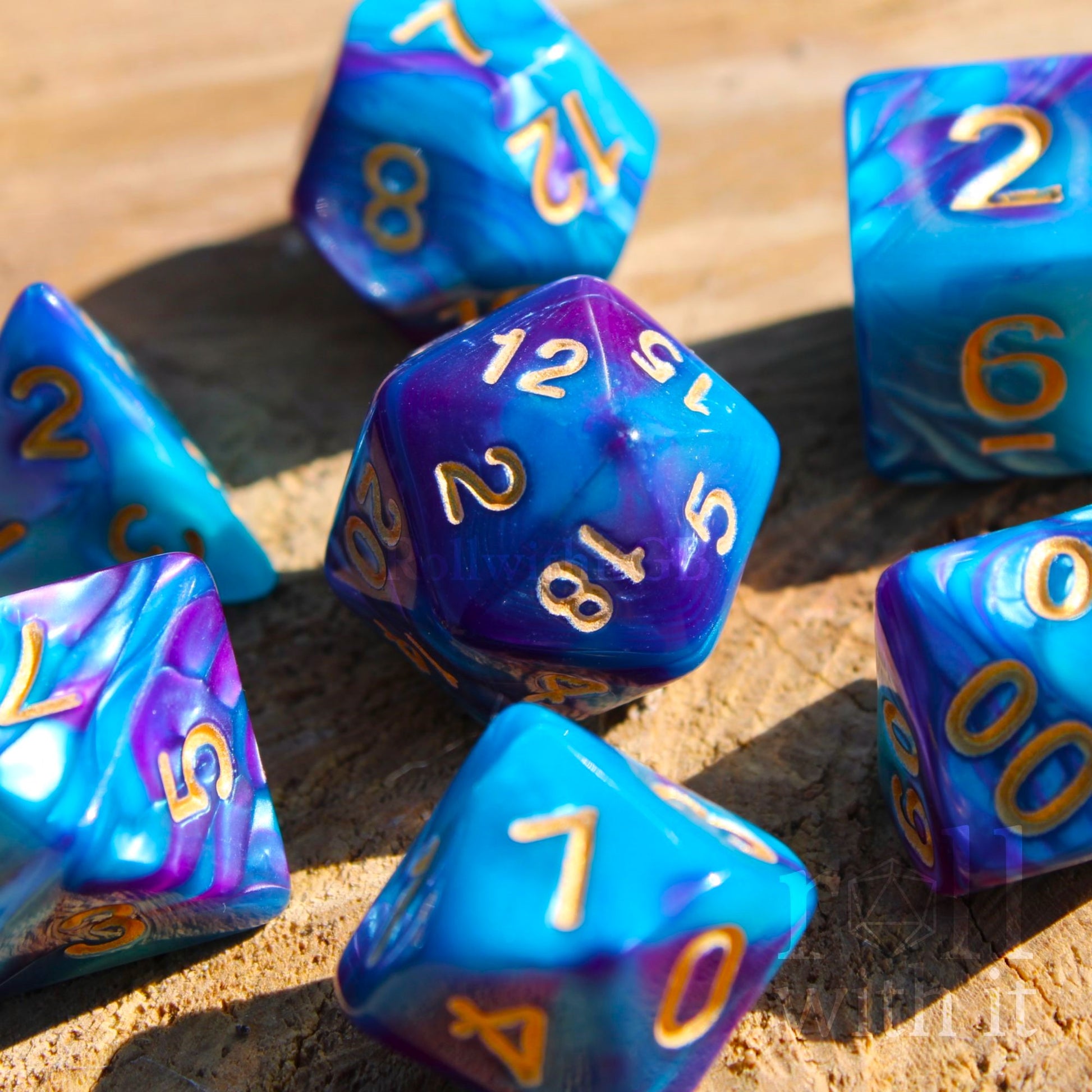 A set of retro 80's colorful purple and blue polyhedral dice with golden numbers on a wooden surface