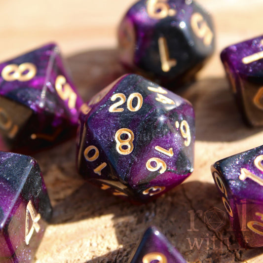 Purple glittering polyhedral dnd dice set with gold numbers on a wooden surface