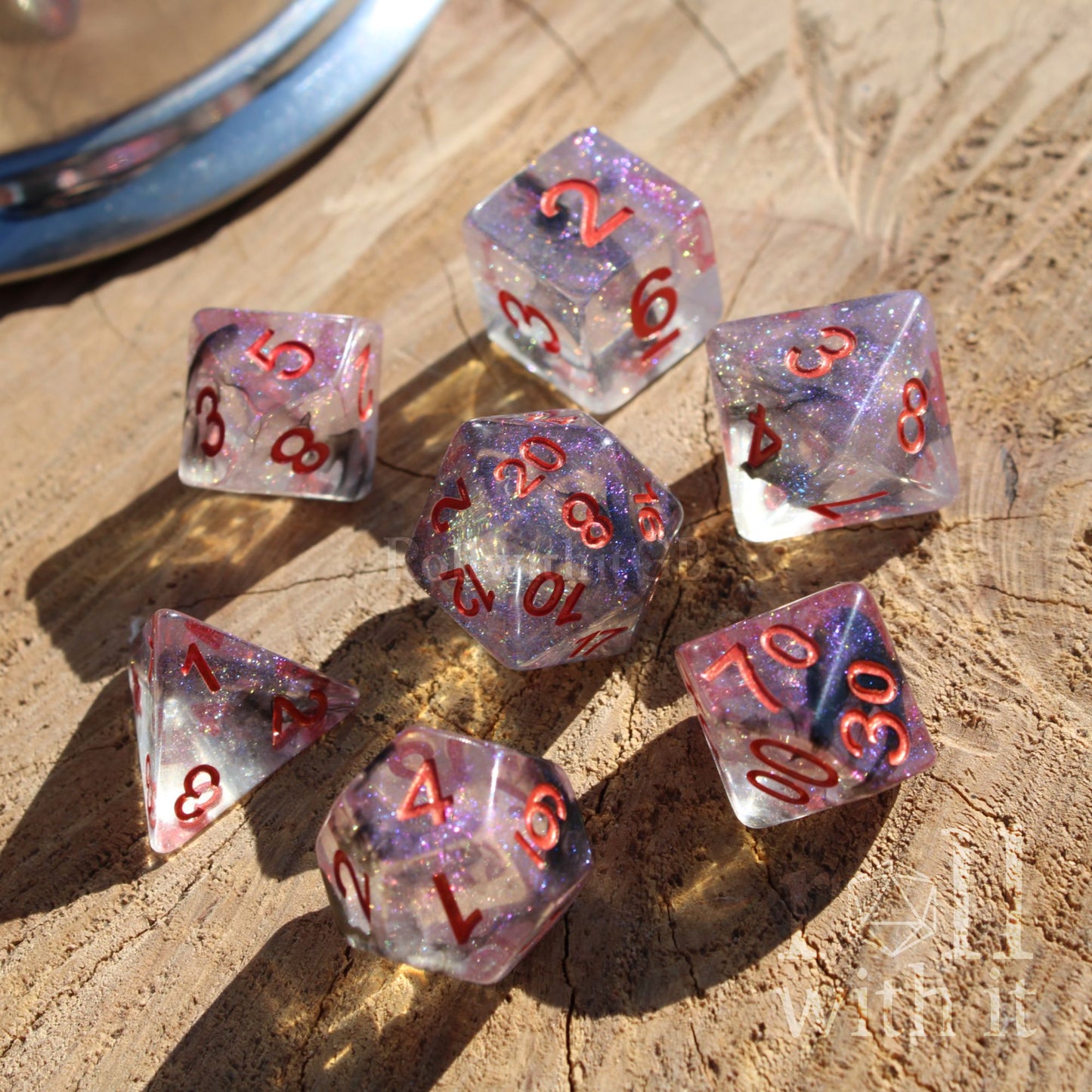 Set of 7 purple transparent TTRPG polyhedral dice with red numbers on a wooden surface