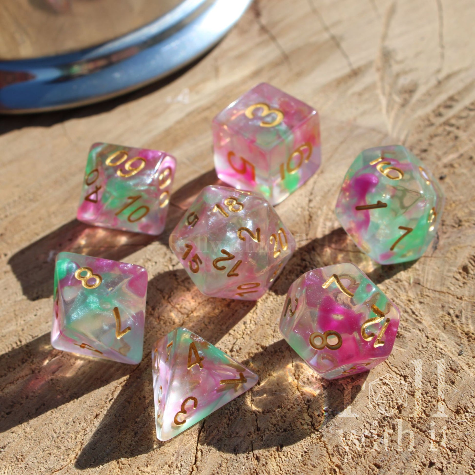 Set of colorful clear dnd purple green gold letters polyhedral dice on a wooden surface