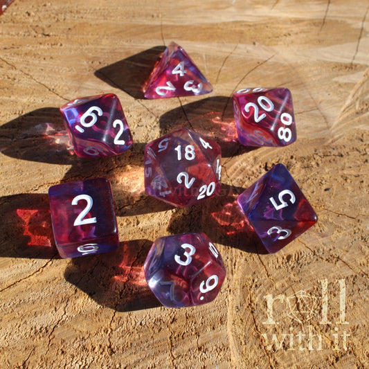 Purple and red clear mixed dnd dice set on a wooden surface with 'roll with it' text.