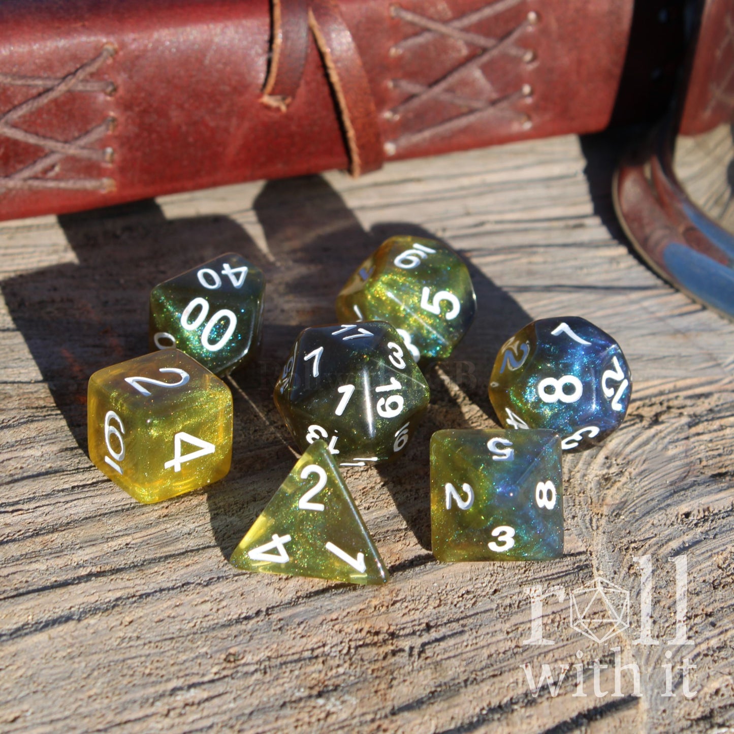 Set of rpg polyhedral dice with green and blue hues on a wooden surface