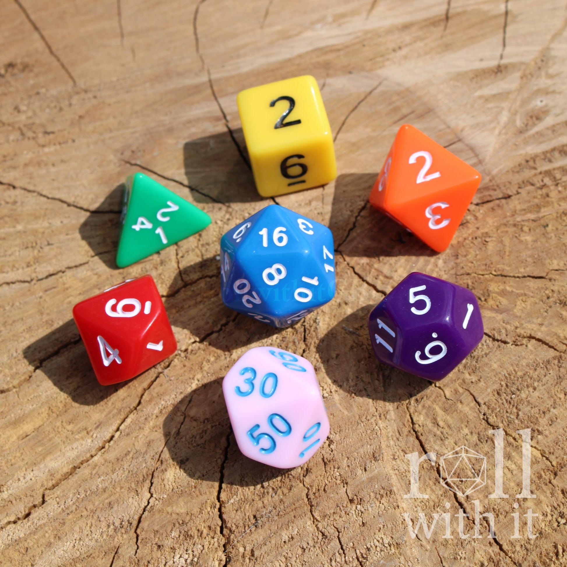 Colorful rainbow DND dice on a wooden surface with 'roll with it' branding.