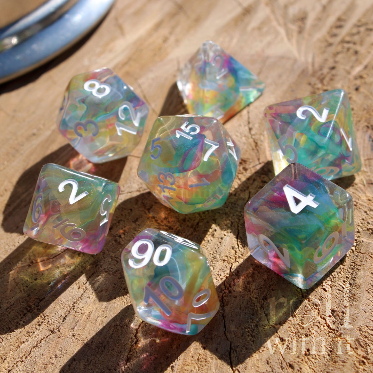 Set of colorful rainbow polyhedral dice on a wooden surface