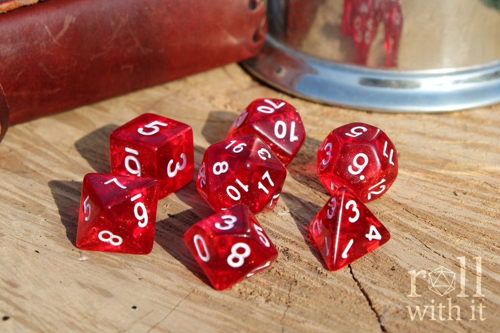 Scarlet red glittery polyhedral roleplaying dice with white numbers on a surface