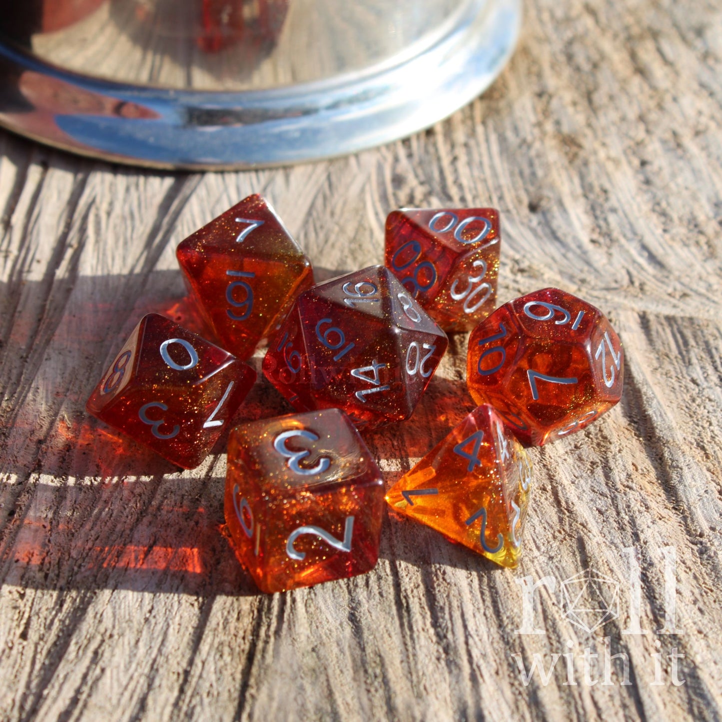 Set of shiny red and orange polyhedral dice on a wooden surface
