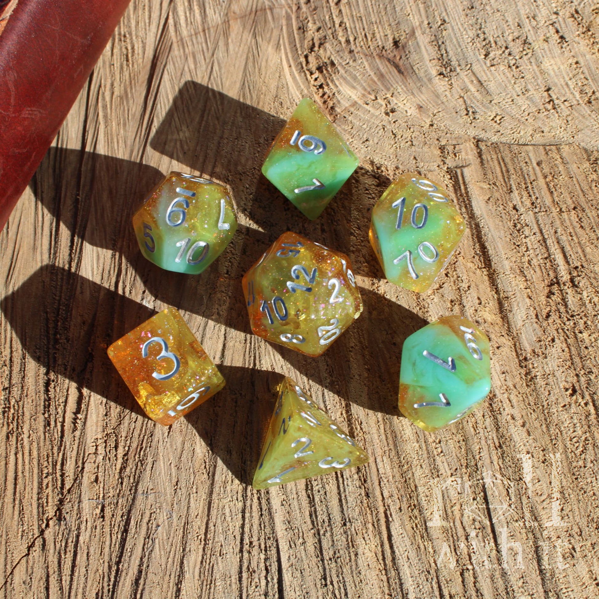Set of colorful gold yellow teal blue polyhedral dice on a wooden surface