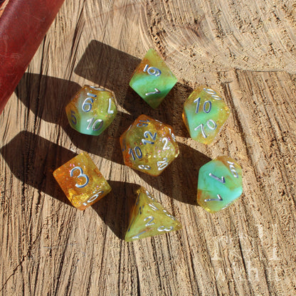 Set of colorful gold yellow teal blue polyhedral dice on a wooden surface
