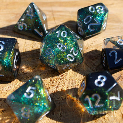 Set of glittery black and starry galaxy like polyhedral dice on a wooden surface