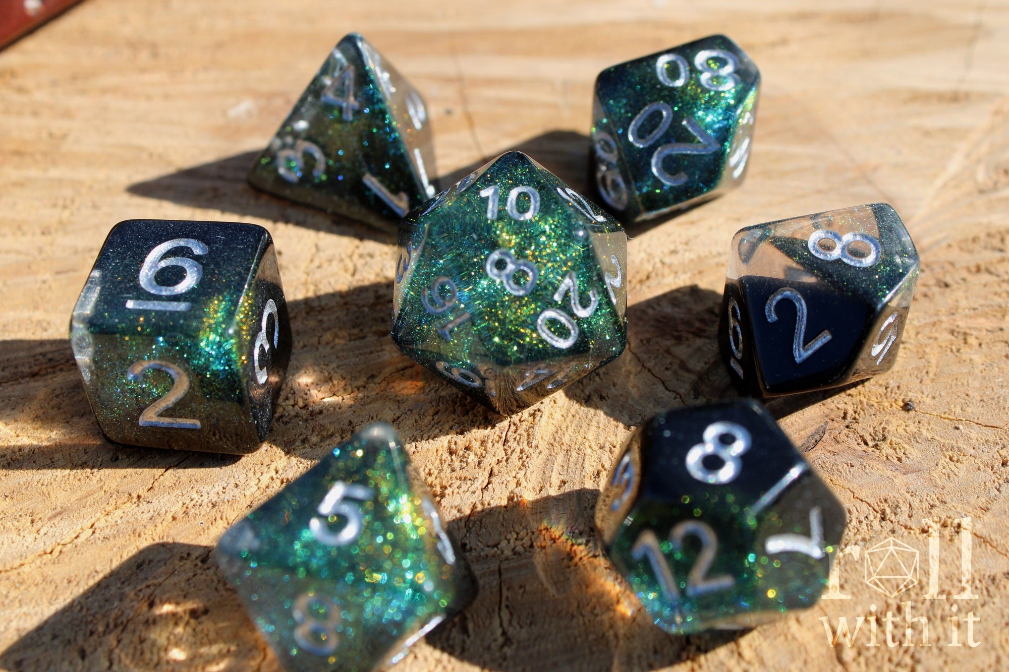Set of glittery black and starry galaxy like polyhedral dice on a wooden surface