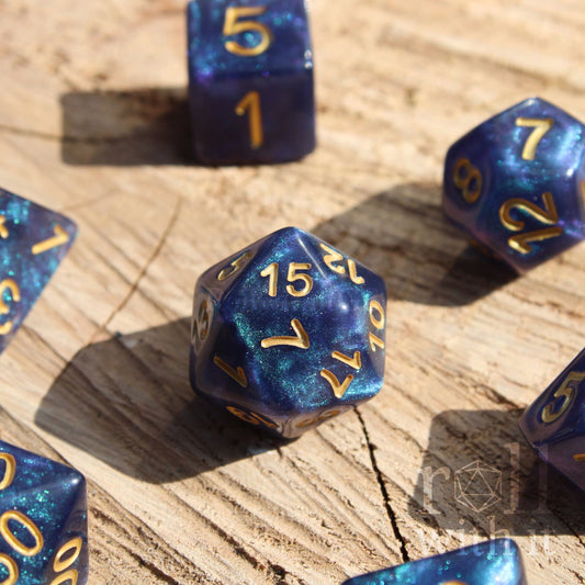 Deep blue and glittery polyhedral roleplaying dice with gold numbers on a wooden surface