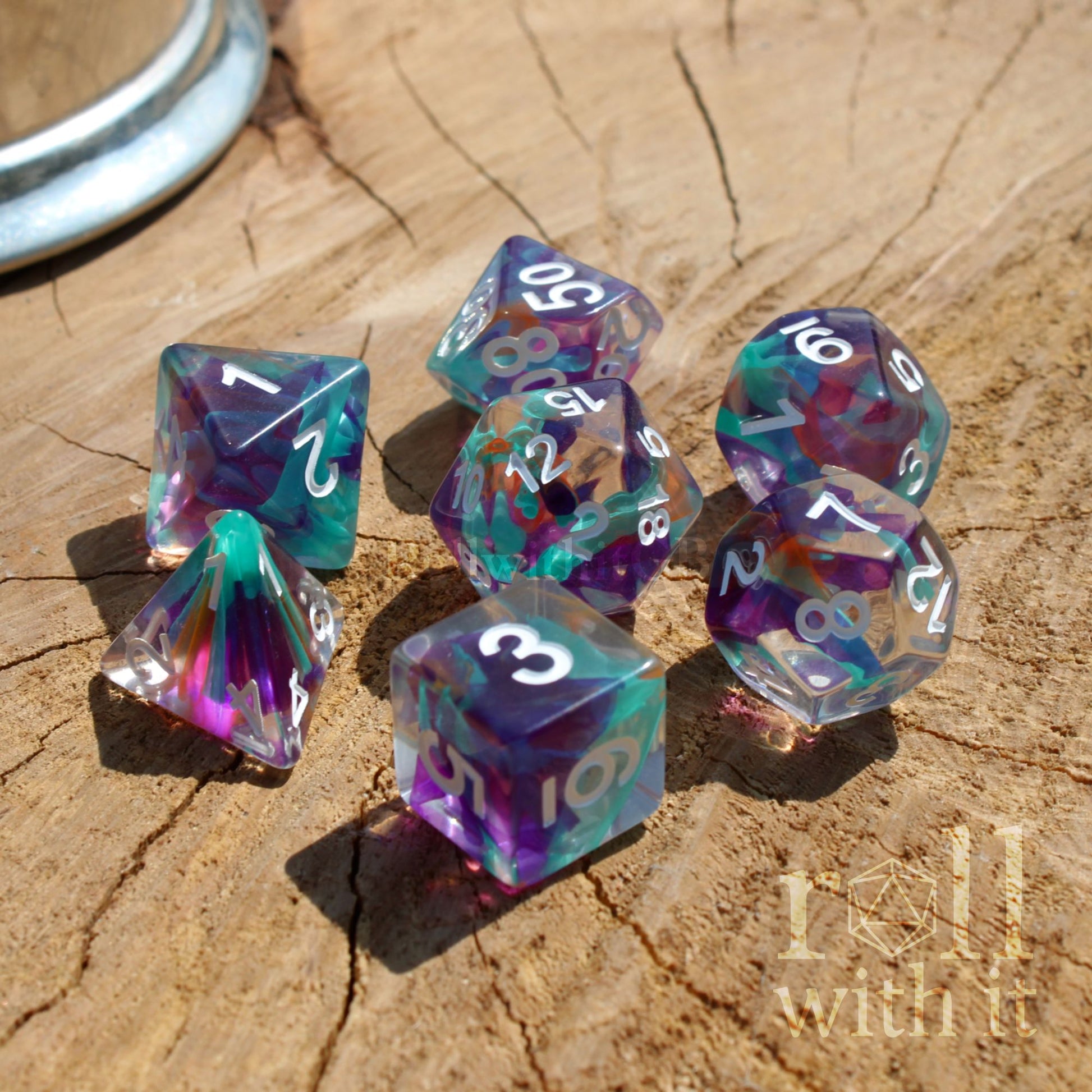 Set of colorful rainbow white numbers polyhedral dice on a wooden surface with a brand logo in the corner.