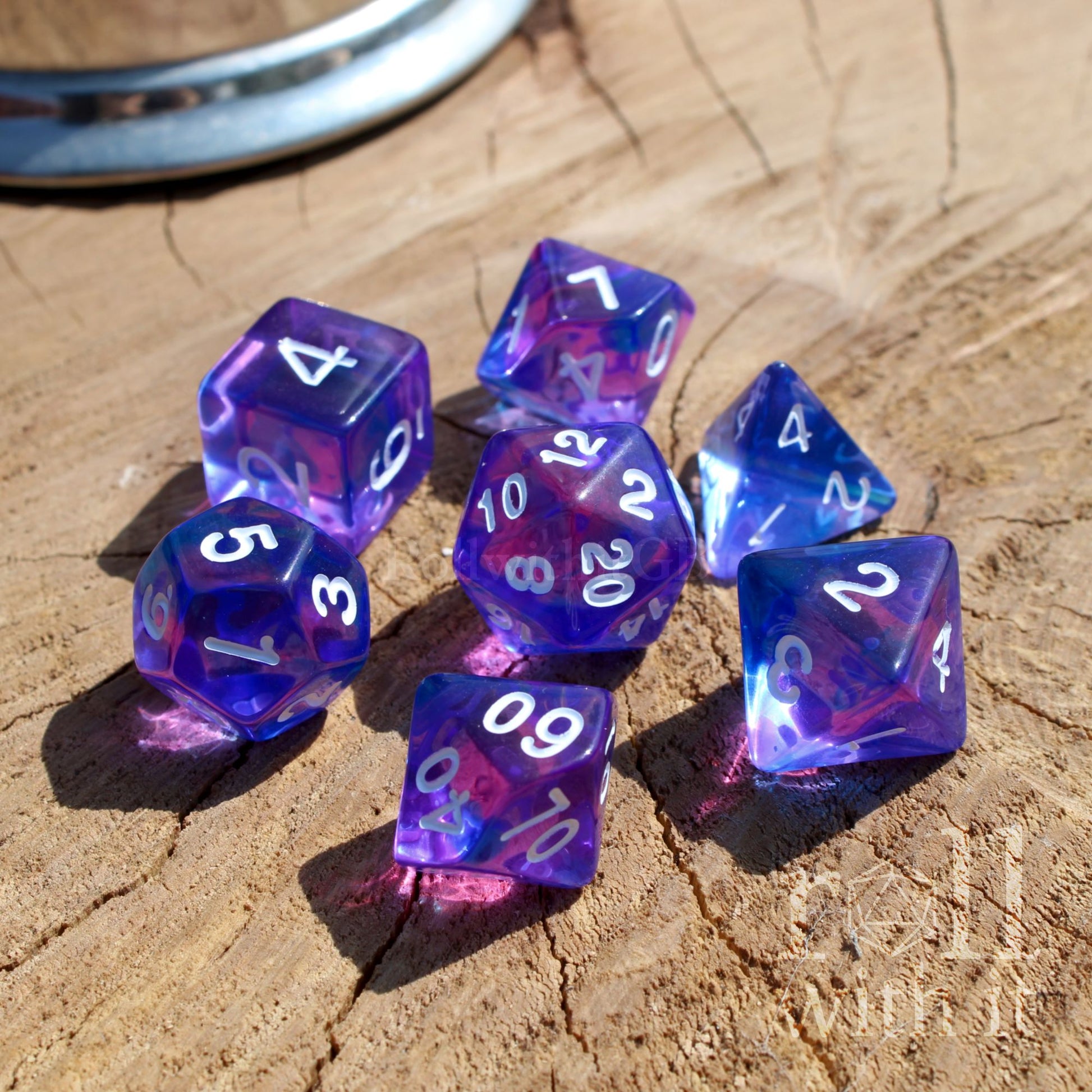 Set of polyhedral TTRPG purple and blue dice with white numbers on a wooden surface