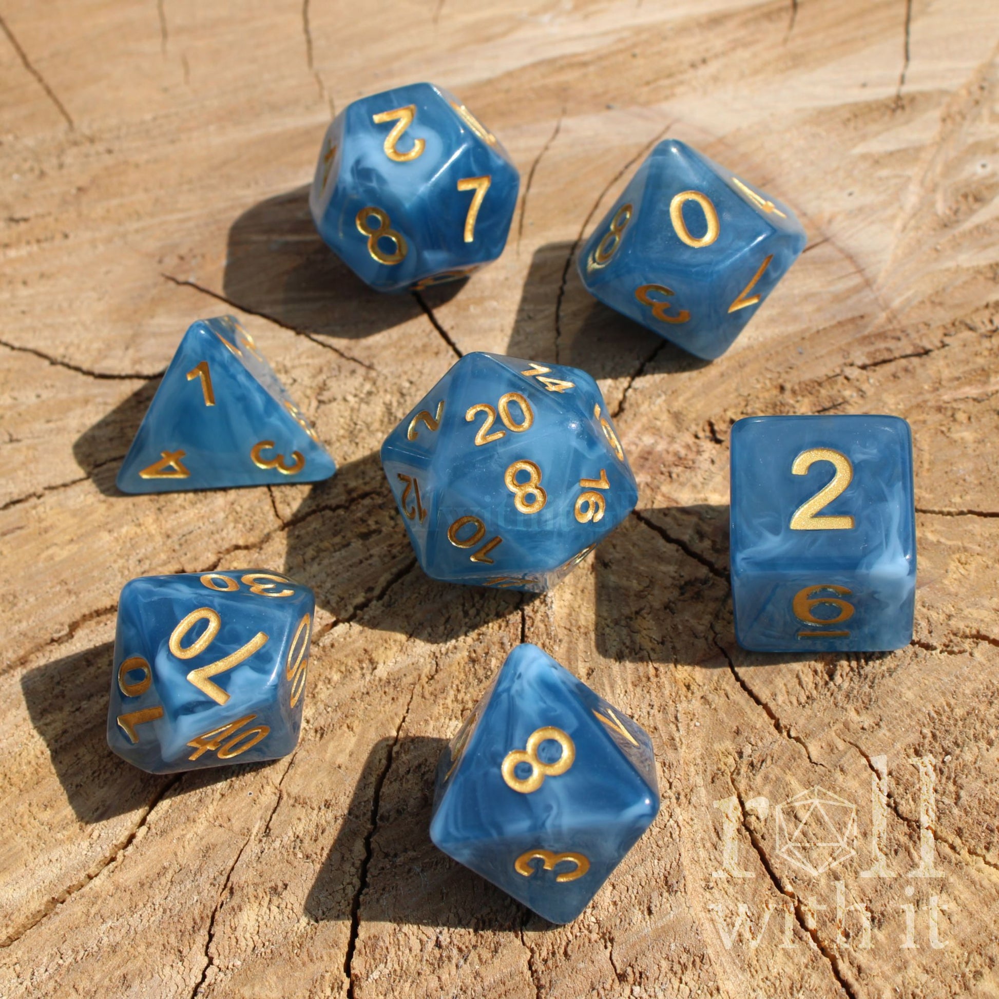 Blue swirling jade polyhedral dice with gold numbers on a wooden surface