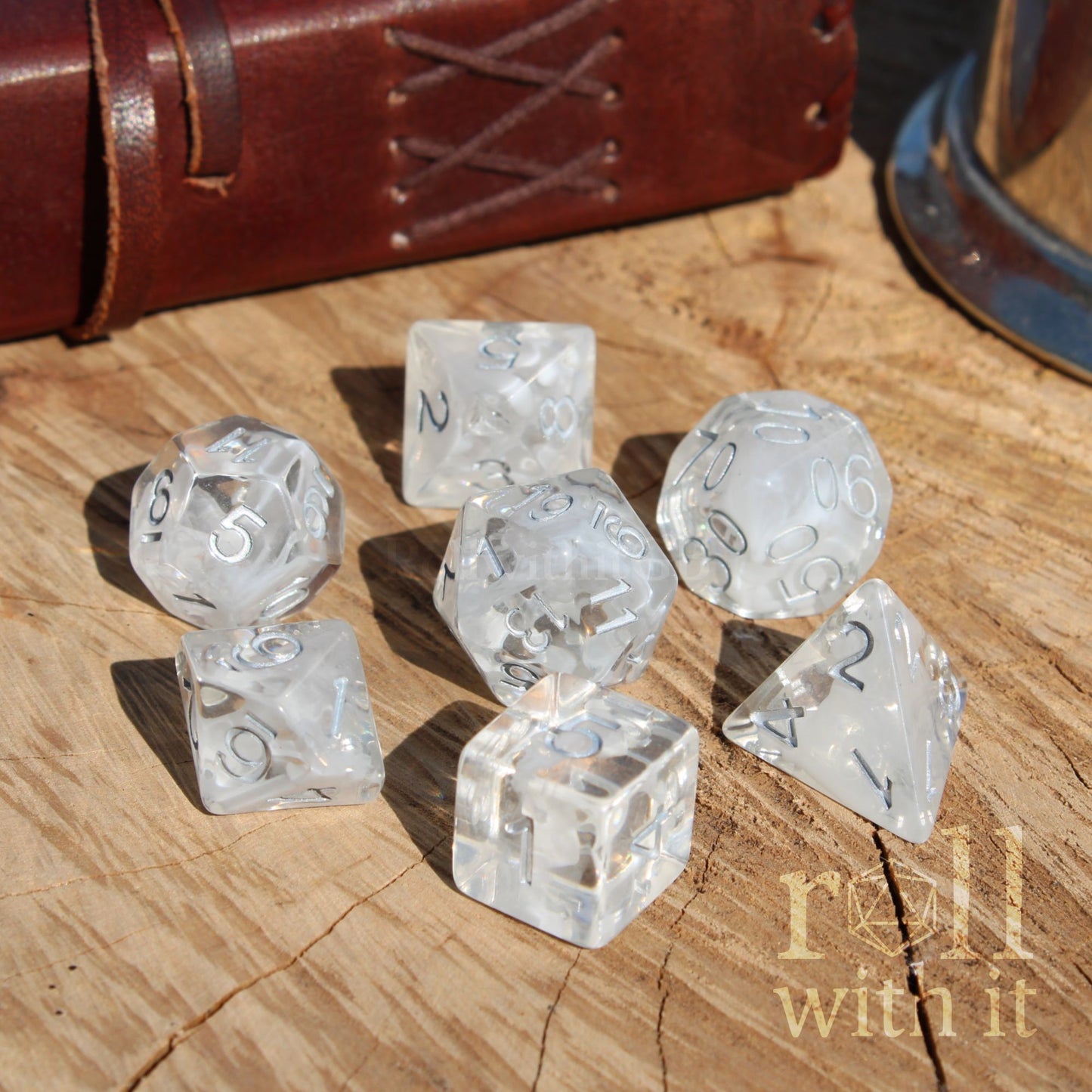 Clear white silver numbers dice set on a wooden surface with 'roll with it' text.