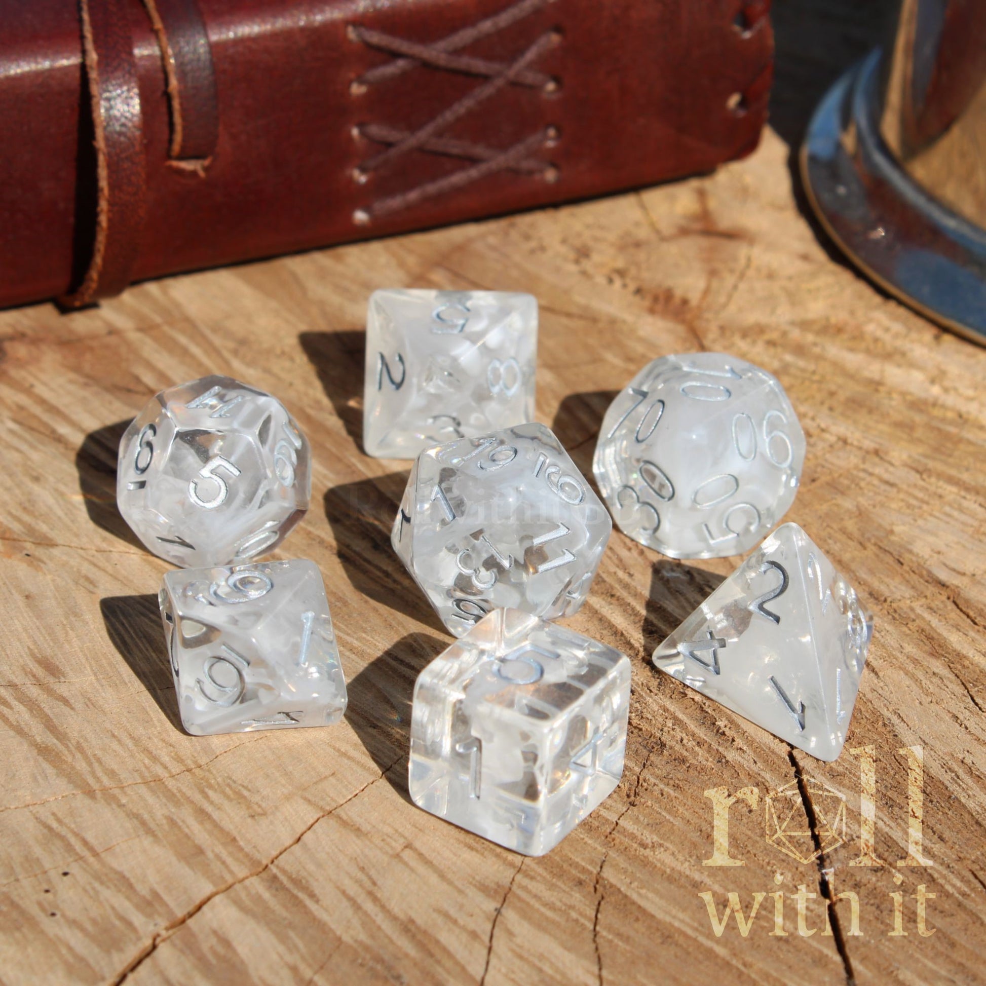 Clear white silver numbers dice set on a wooden surface with 'roll with it' text.