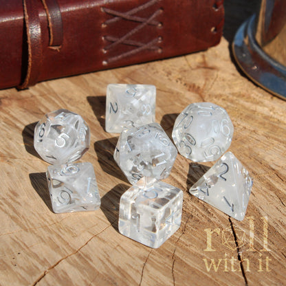 Clear white silver numbers dice set on a wooden surface with 'roll with it' text.