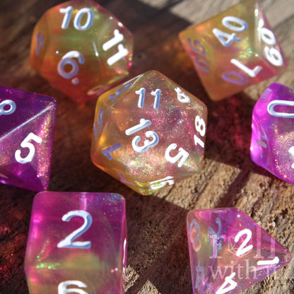 Colorful purple yellow glitter polyhedral dice with white numbers on a wooden surface