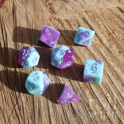 Set of multicolored lilac baby blue pale dnd polyhedral dice on a wooden surface