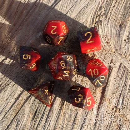 Set of polyhedral dice with red and black colors on a wooden surface