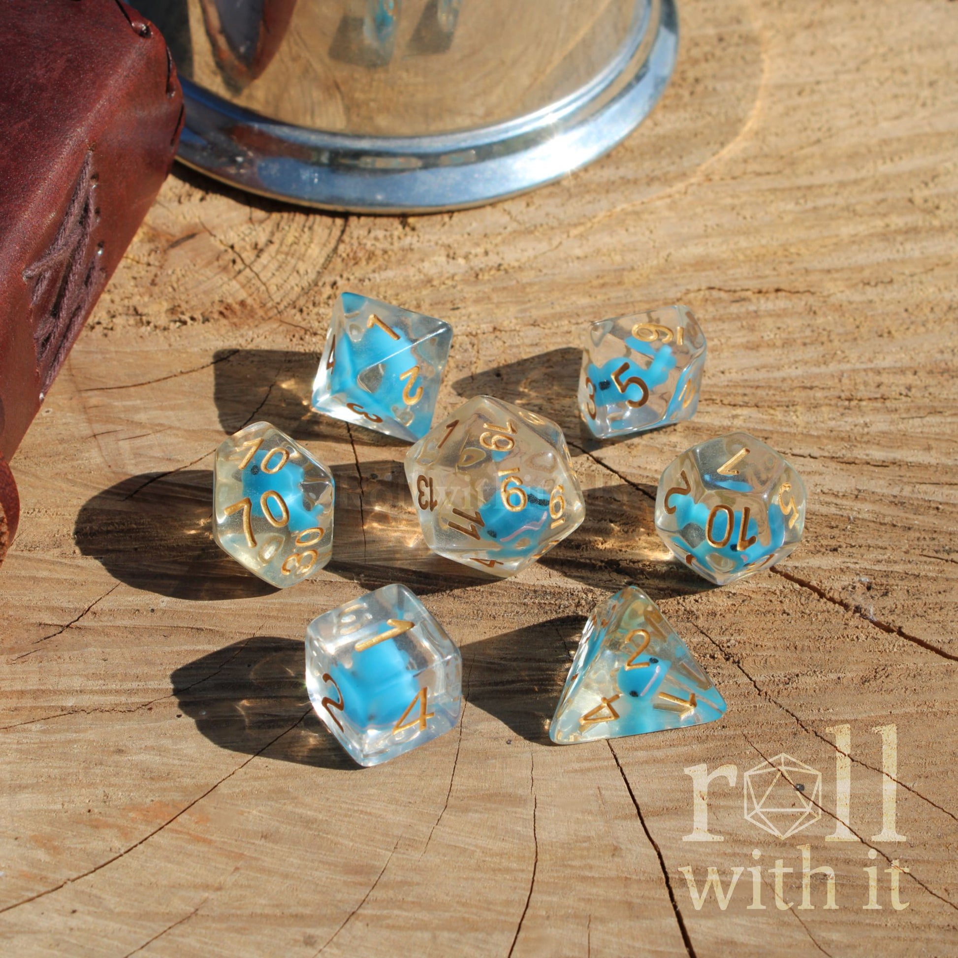 A set of 7 cute balance blue whale dice on a wooden surface with golden numbers