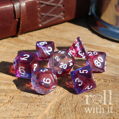 Set of purple and clear polyhedral dice on a wooden surface with 'roll with it' branding.