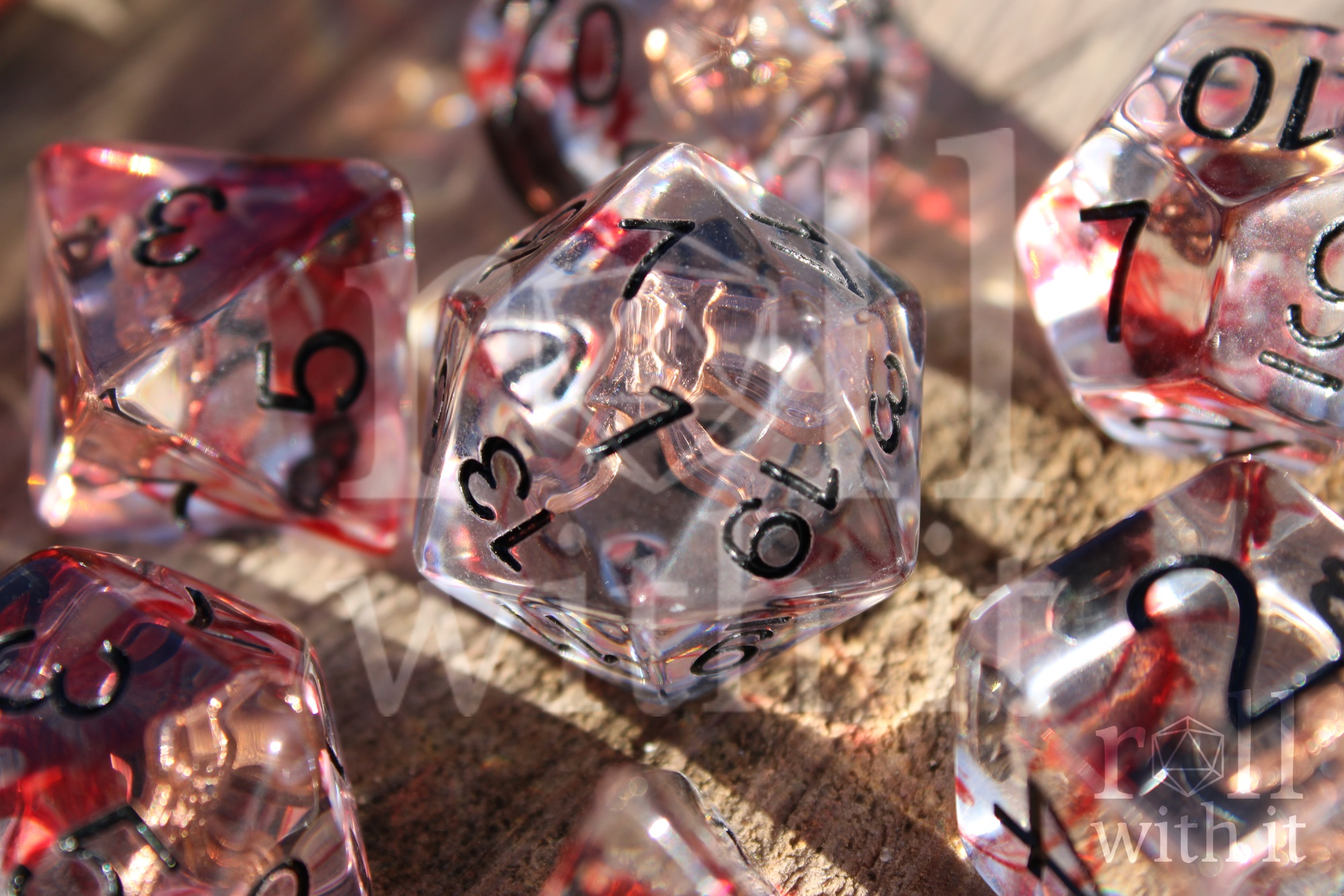 Set of transparent dice with red and black numbers on a wooden surface with rogues daggers inside