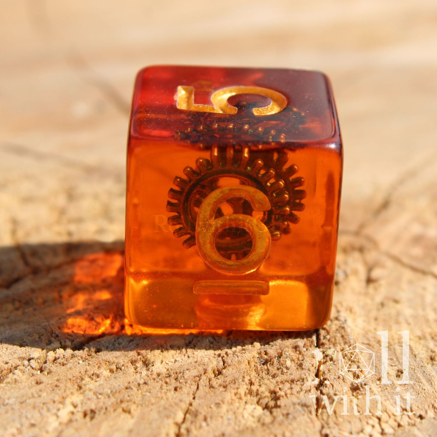 Translucent orange dice with gold numbers and a copper cog inside on a wooden background