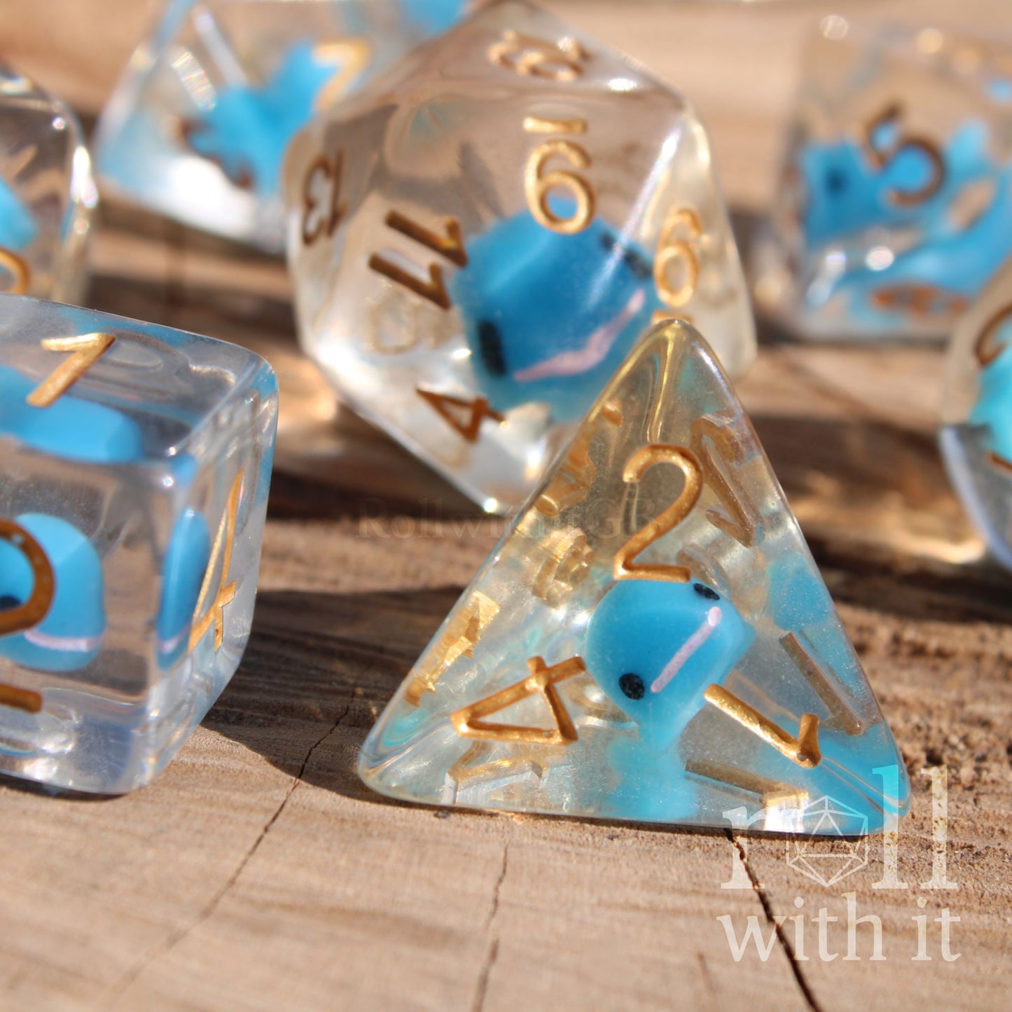 A set of balanced clear dice with a cute blue whale inside on a wooden surface