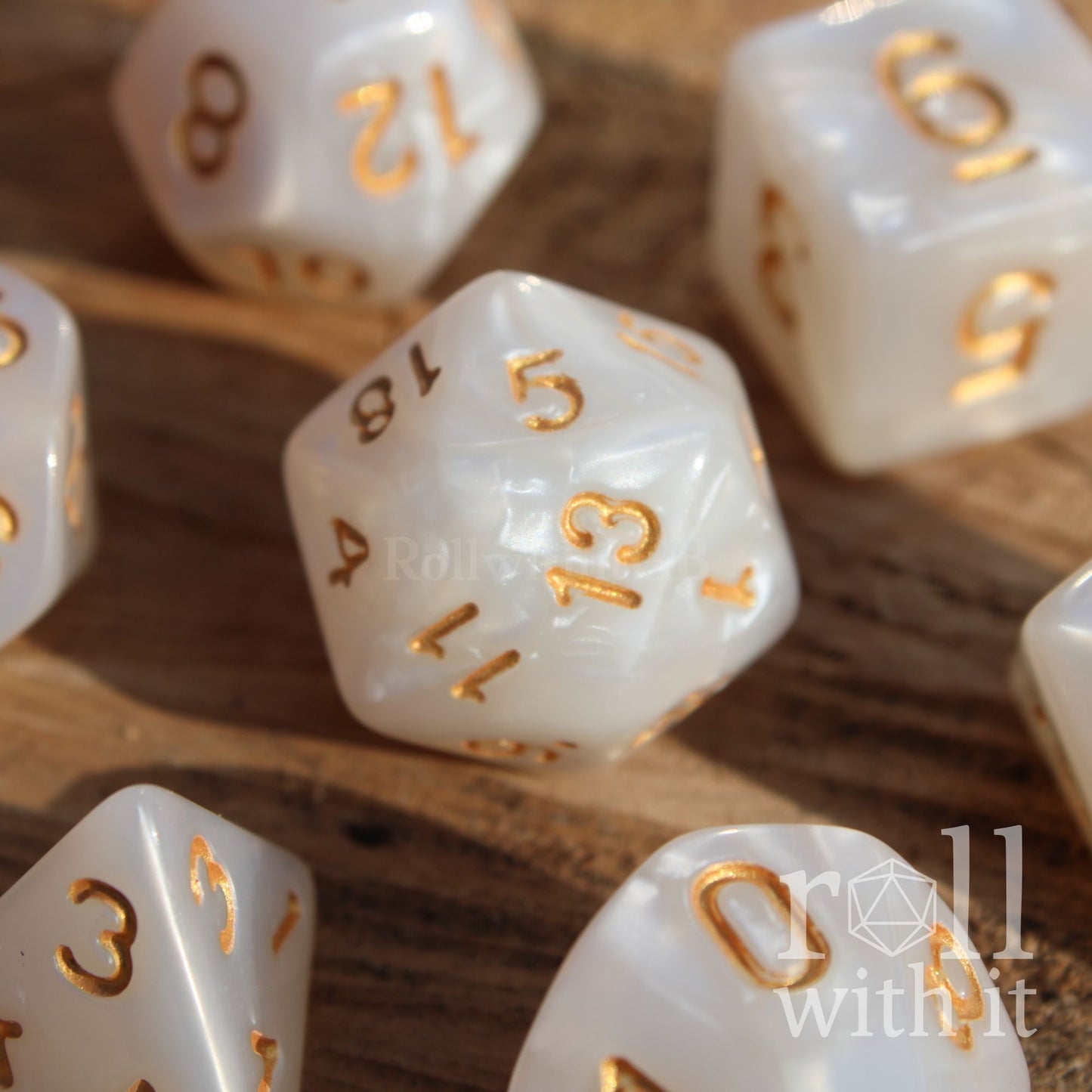 A closeup of 7 white dnd pearl ttrpg dice on a wooden surface