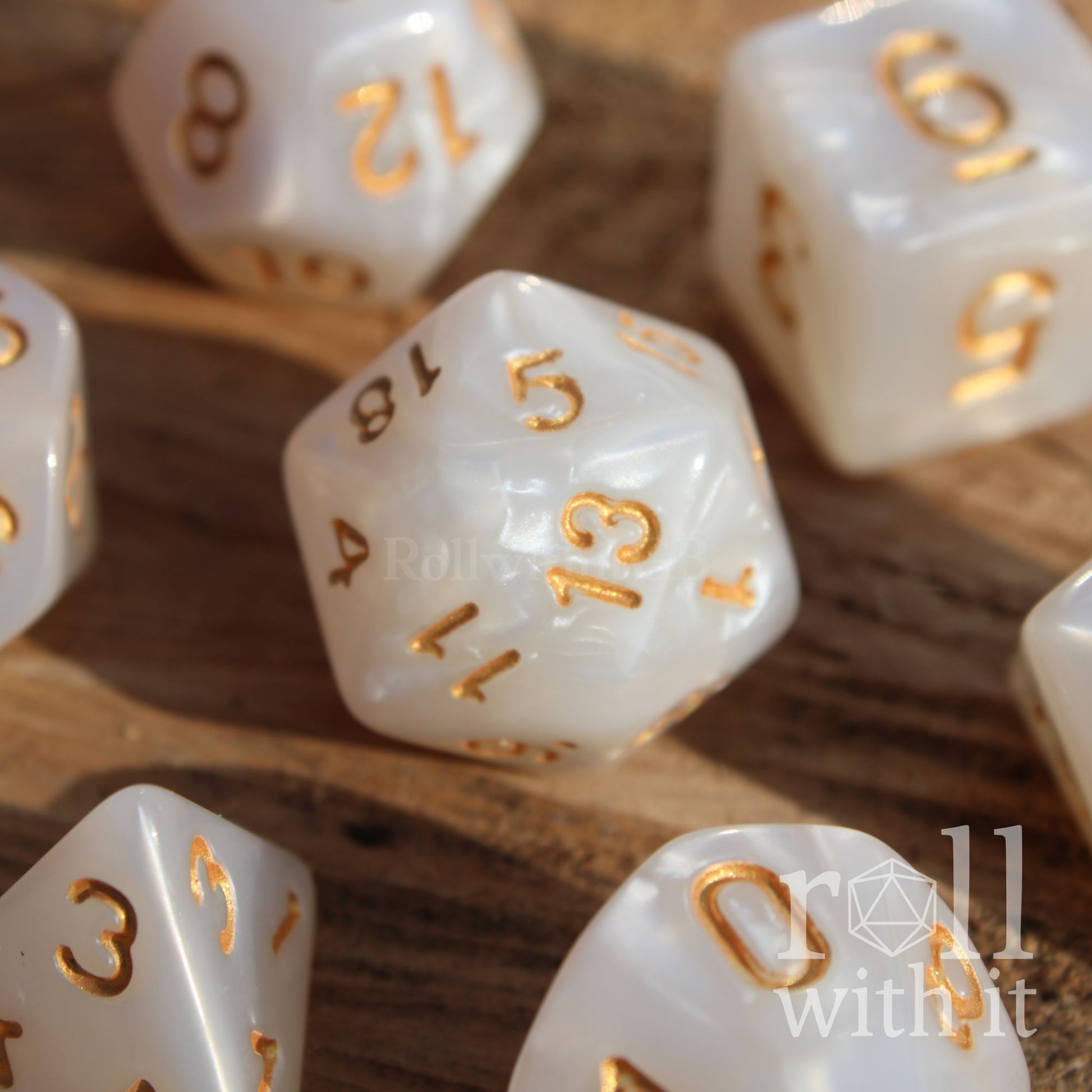 A closeup of 7 white dnd pearl ttrpg dice on a wooden surface