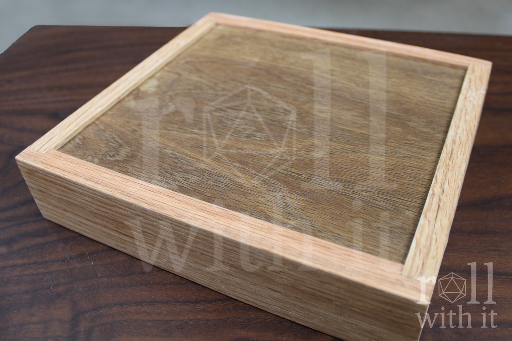 Reverse side of a wooden red oak dice tray. The veneer oak bottom is slightly inset into the rest of the box.