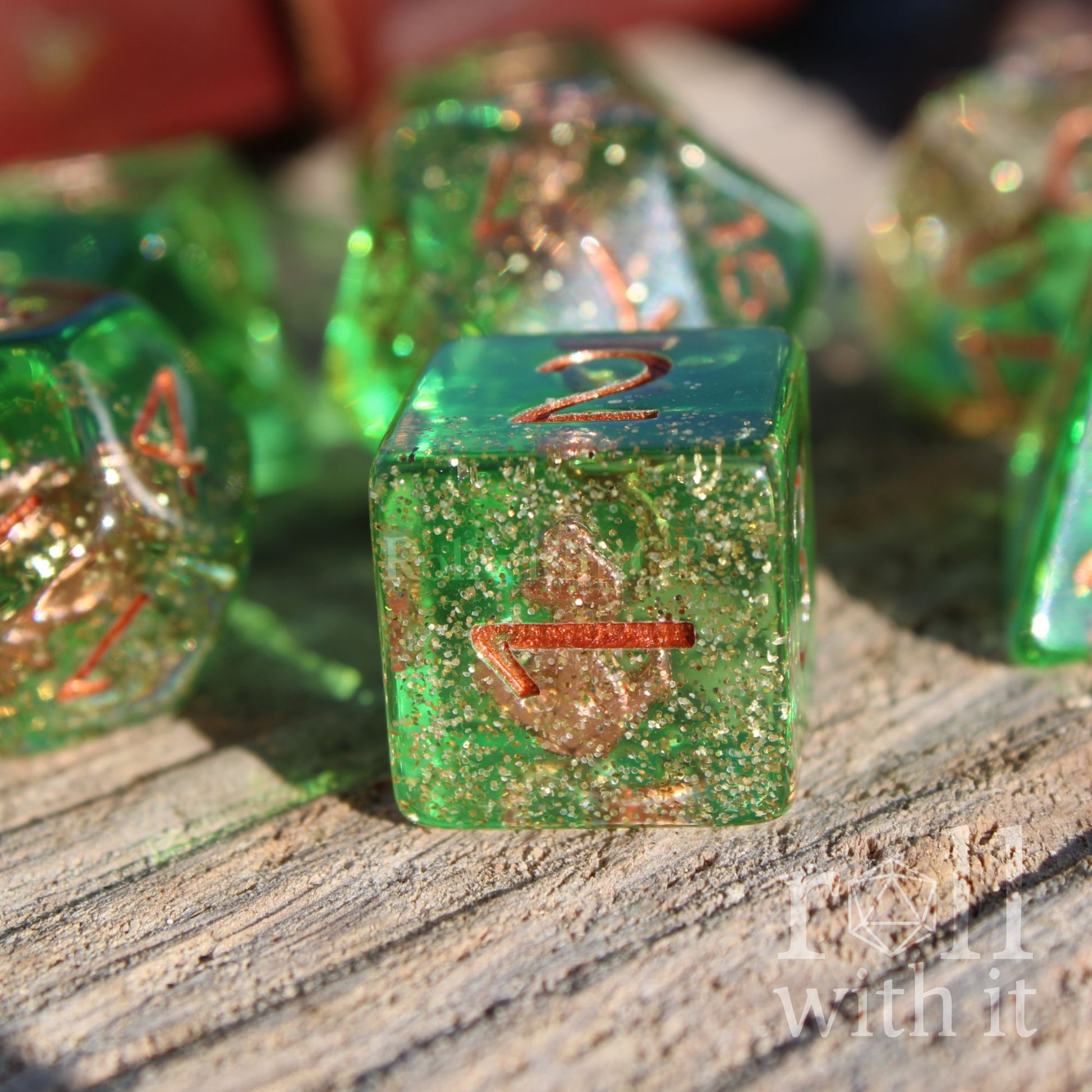 Green sea themed copper anchor inside glittery dice with copper metalic numbers on a wooden surface