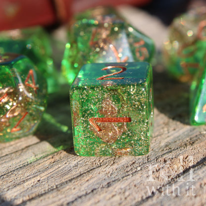 Green sea themed copper anchor inside glittery dice with copper metalic numbers on a wooden surface
