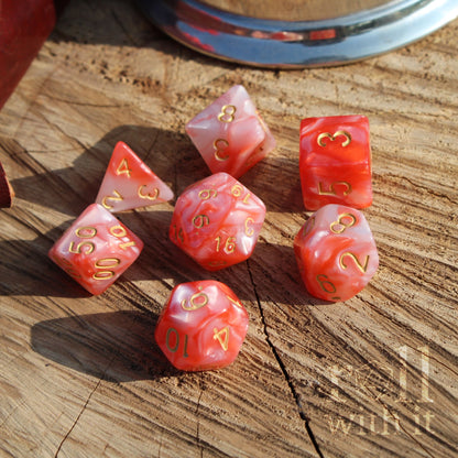 Set of red and pearl mixed white polyhedral dice on a wooden surface