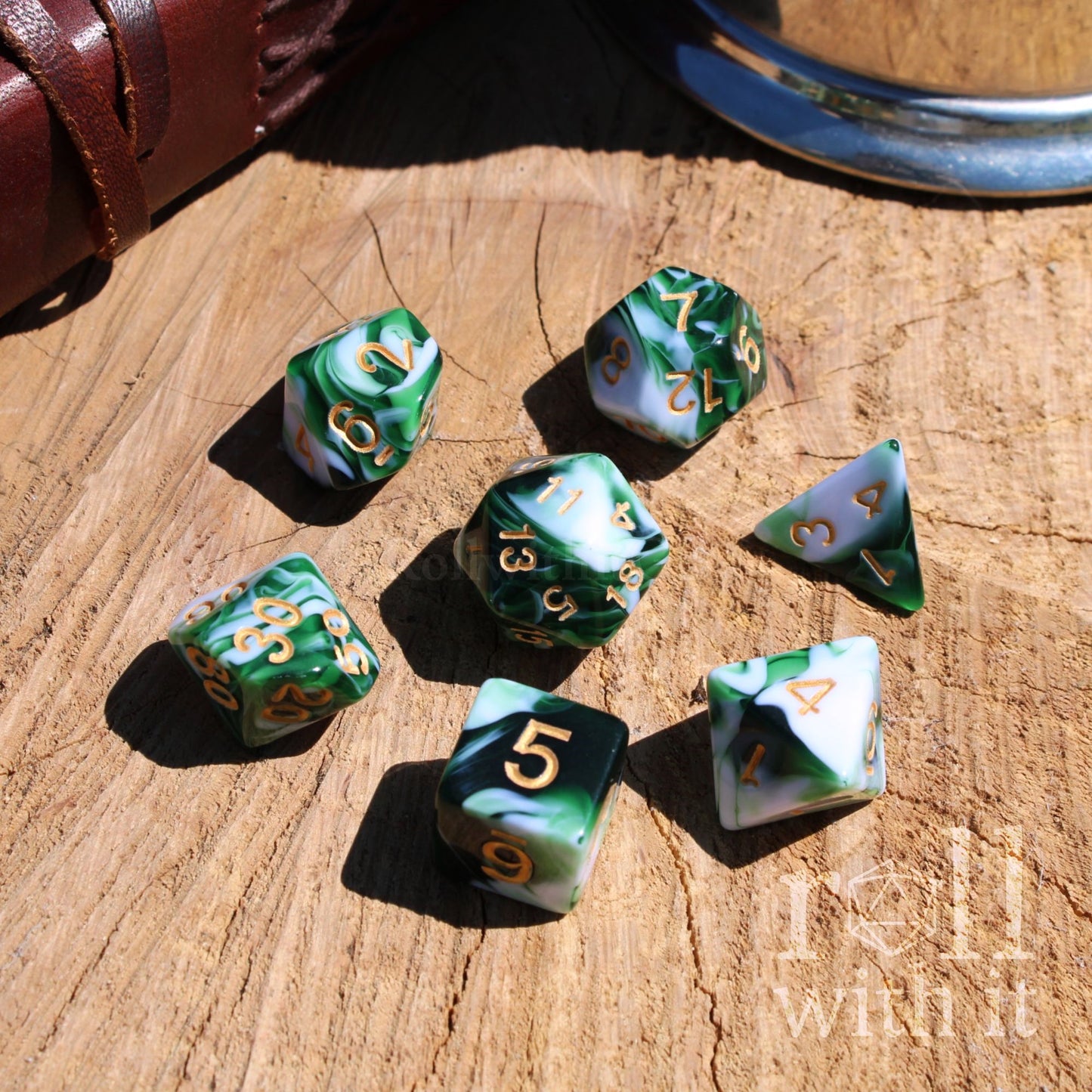 Set of green and white dice with gold numbers on a wooden surface, featuring the brand 'Roll With It'.