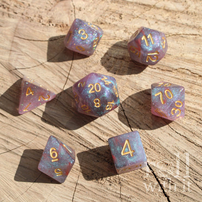 Set of colorful easy to read space purple stars polyhedral dice on a wooden surface