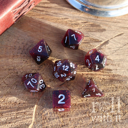 Set of red star like dark space polyhedral dice with silver numbers on a wooden surface