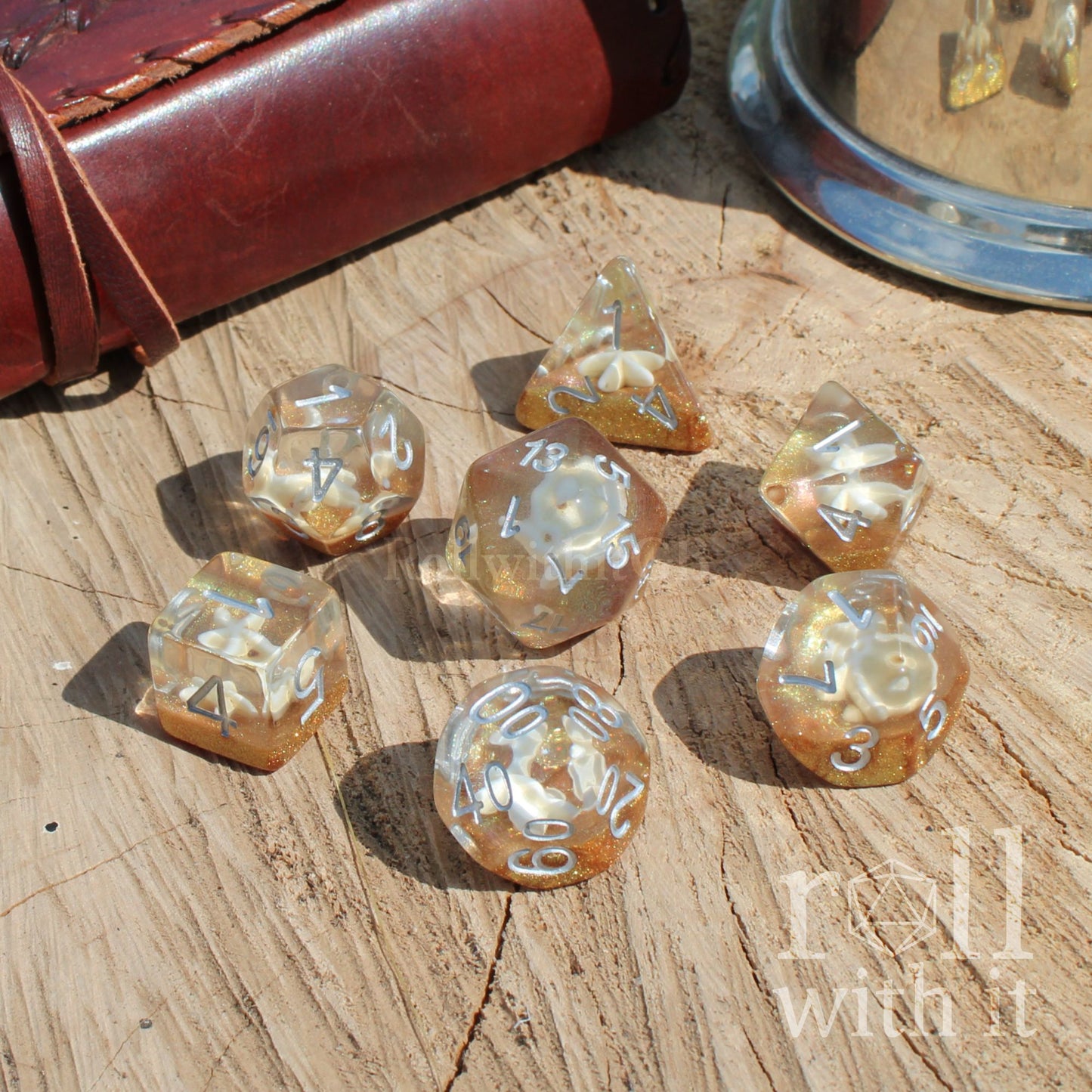 Set of golden yellow glitter dice on a wooden surface with 'roll with it' text