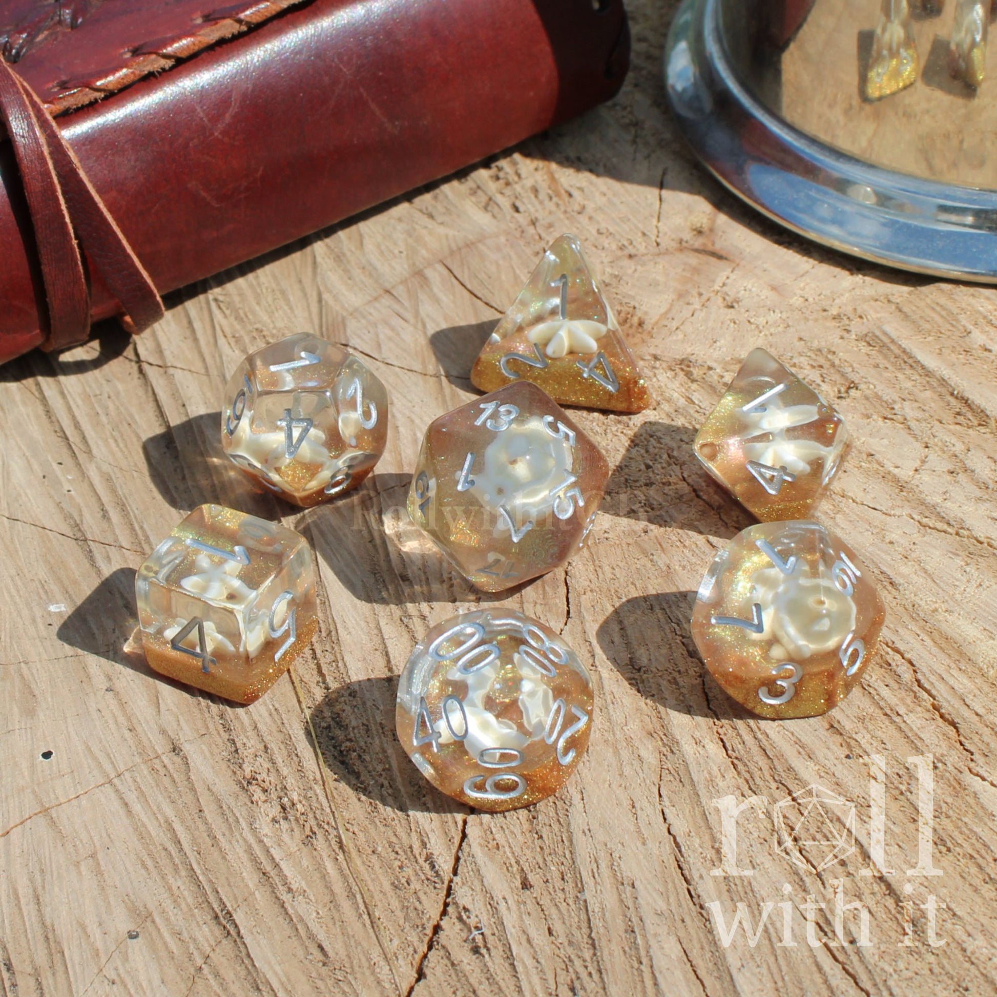 Set of golden yellow glitter dice on a wooden surface with 'roll with it' text