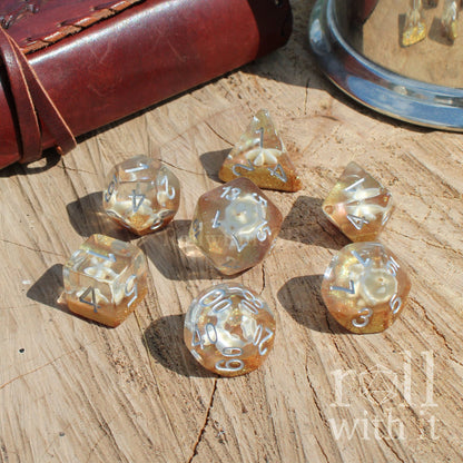 Set of golden yellow glitter dice on a wooden surface with 'roll with it' text
