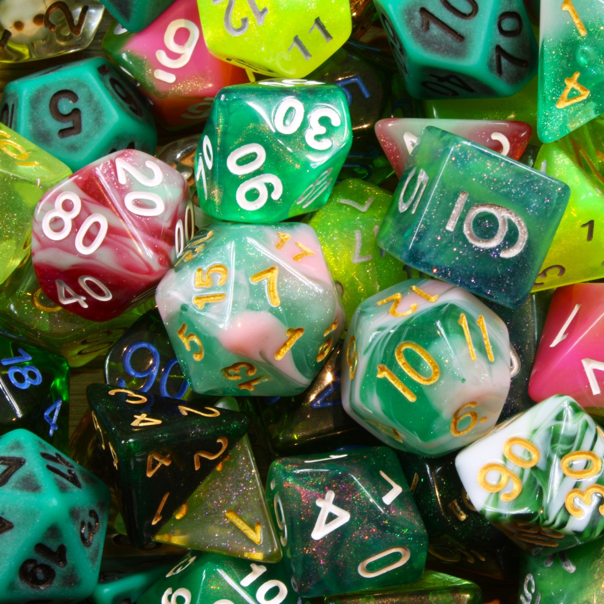 Assorted green, red and pink DnD polyhedral roleplaying dice with various numbers in a pile.