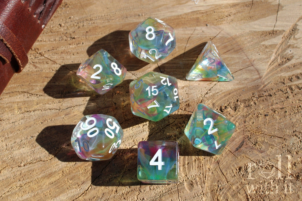Set of colorful swirling rainbow and clear polyhedral dice on a wooden surface