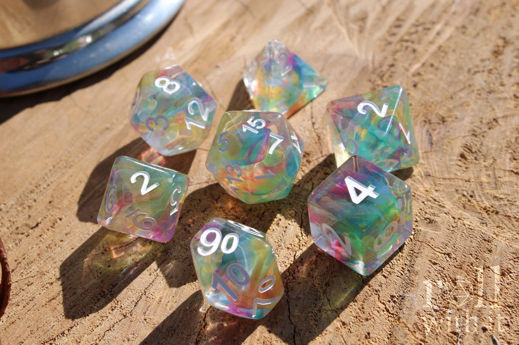 Set of 7 colourful swirling rainbow and clear polyhedral roleplaying dice on a wooden surface