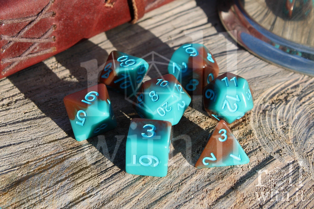 Set of turquoise blue and chocolate brown polyhedral dice on a wooden surface